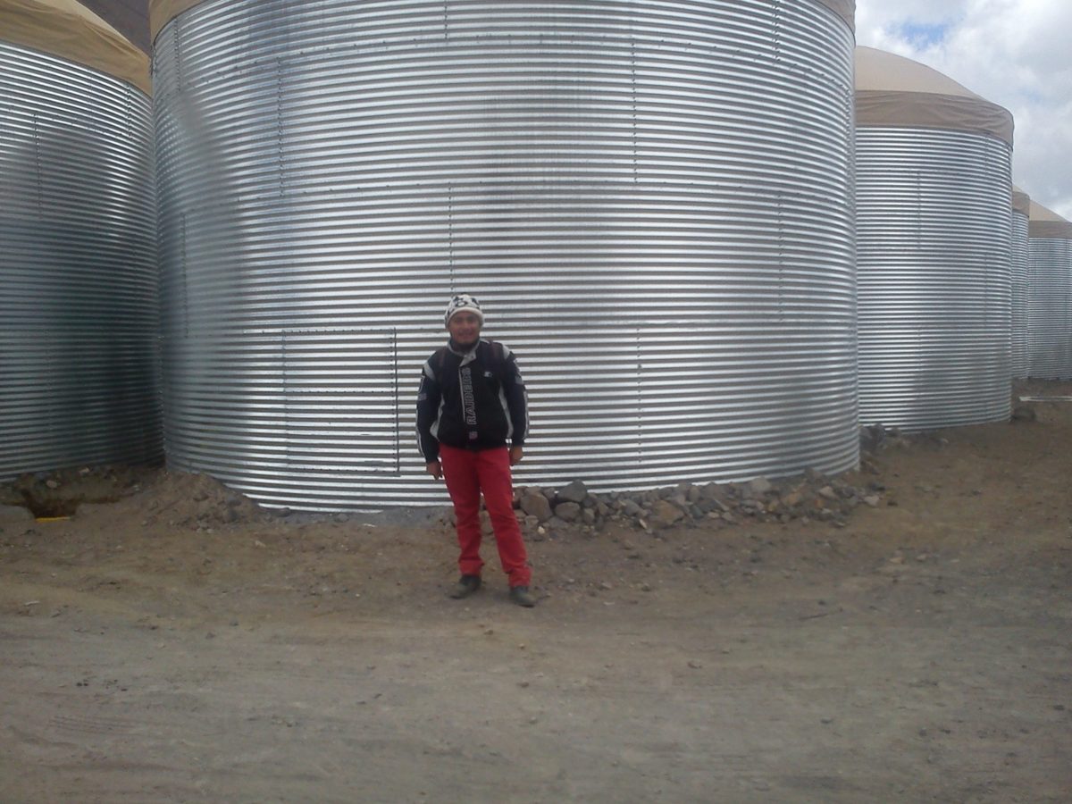 Noel Alberto Cruz Venegas in front of large cylindrical structures
