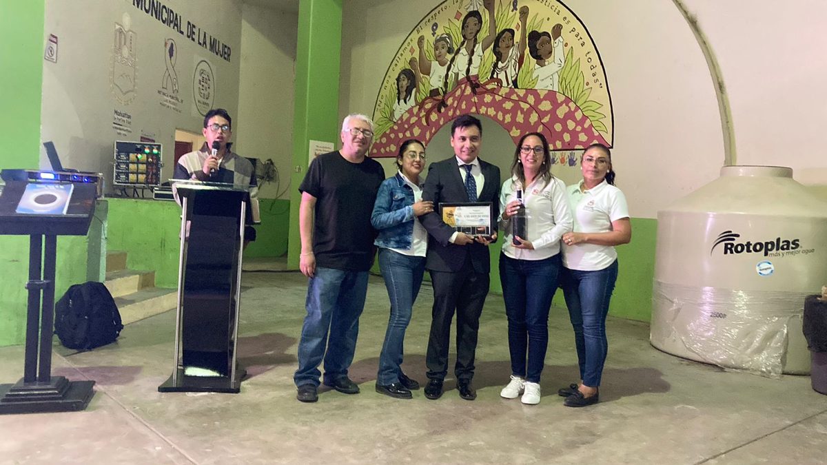 Group photo at a ceremony with a plaque